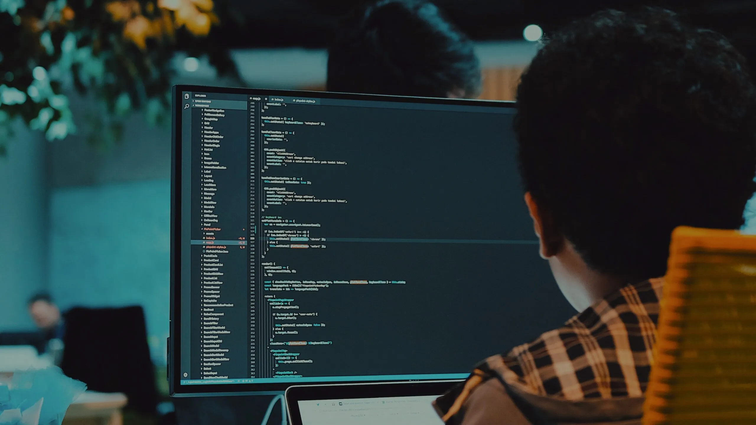 A developer working on code in a dimly lit office