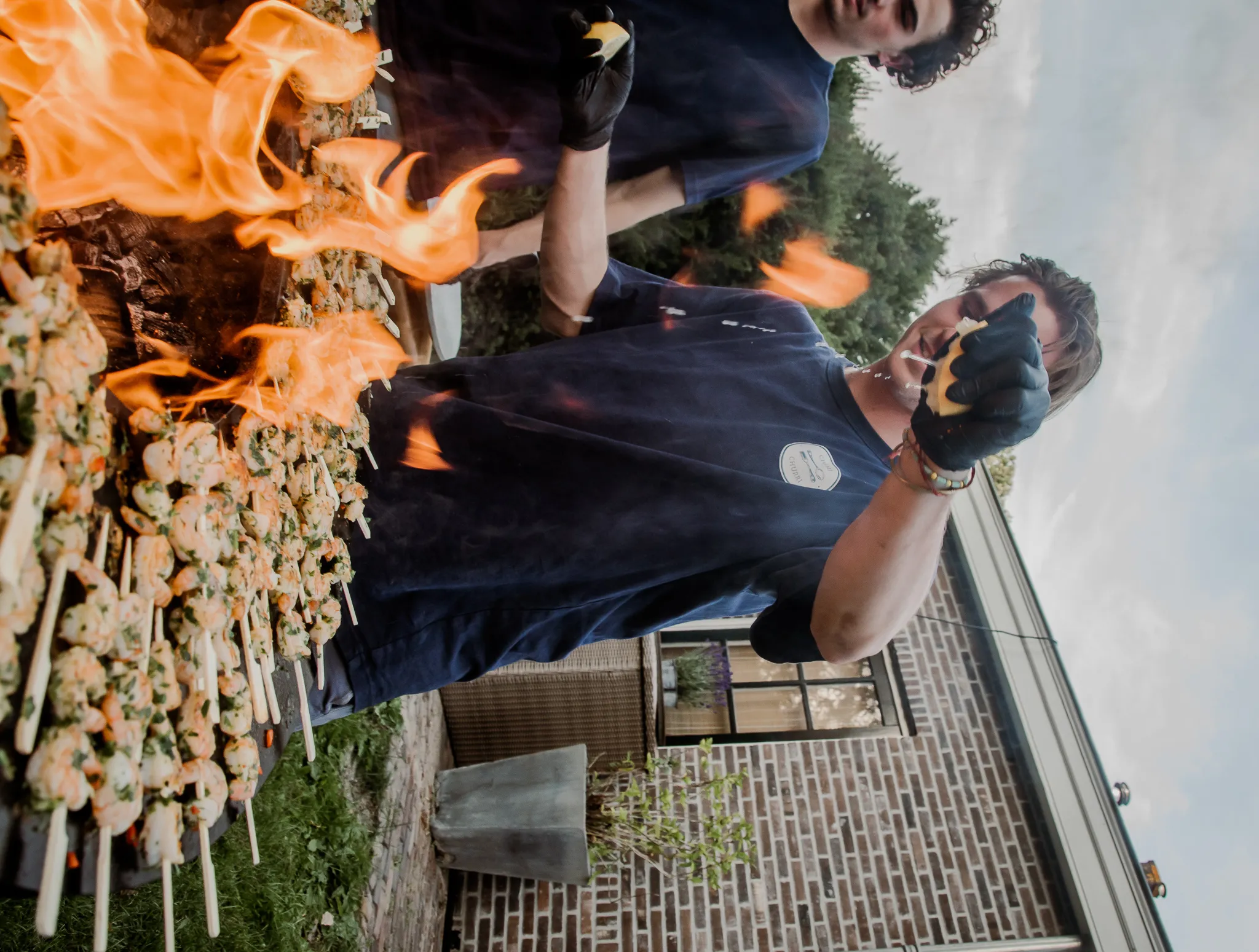 Chefs flame-grilling skewers at a Chimi & Churri event