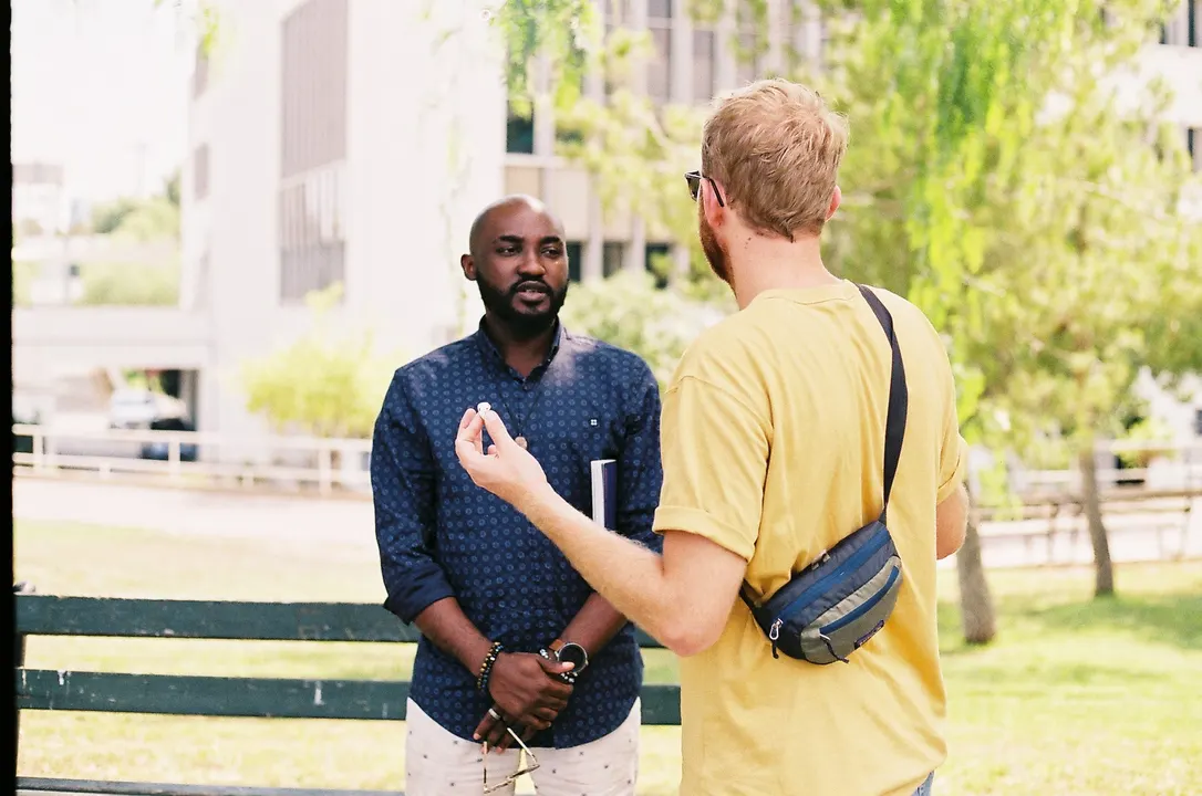 Two men in conversation in a sunny park